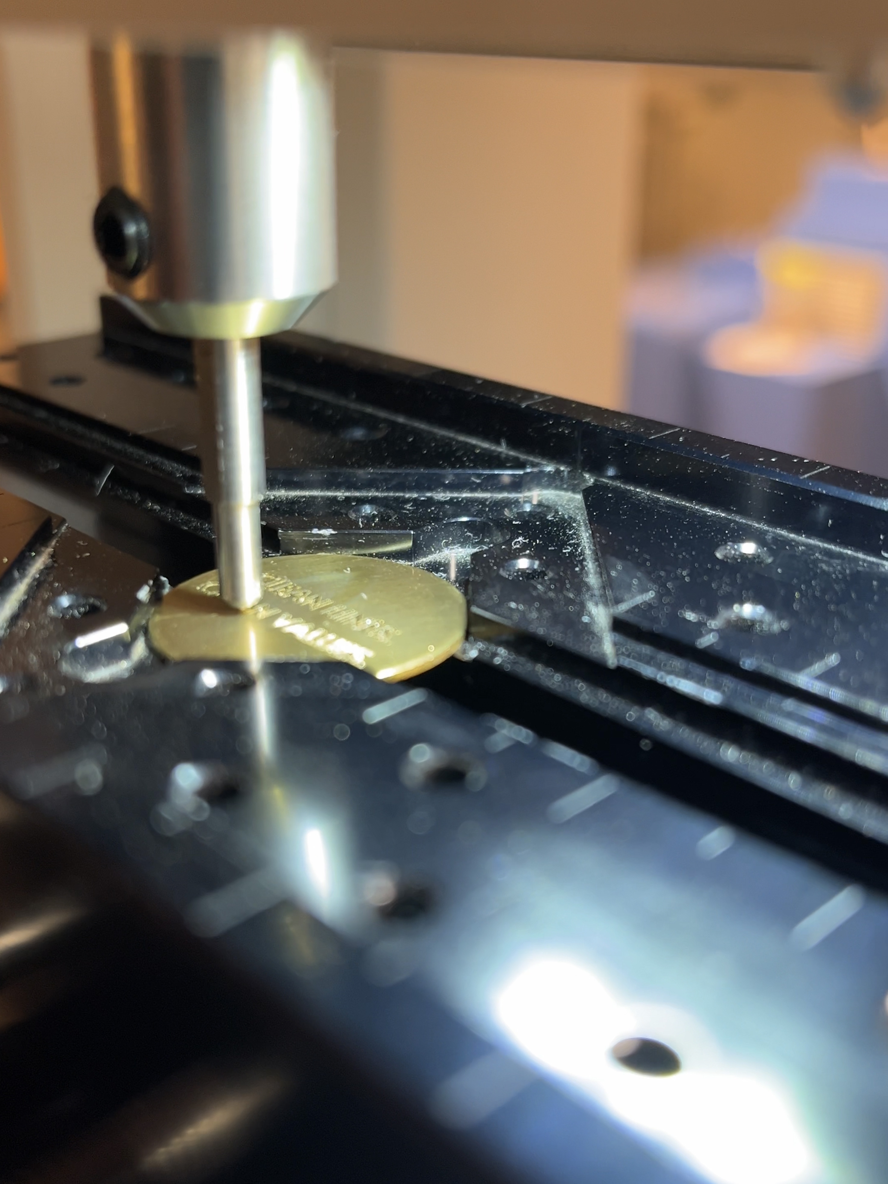 Nahaufnahme einer Graviermaschine, die  einen Messing Anhänger graviert