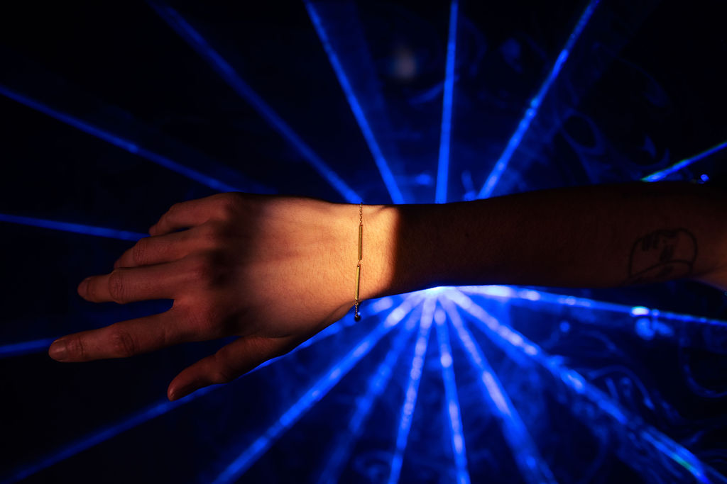 Weibliches Handgelenk das ein filigranes Armband aus Messing von fremdformat trägt